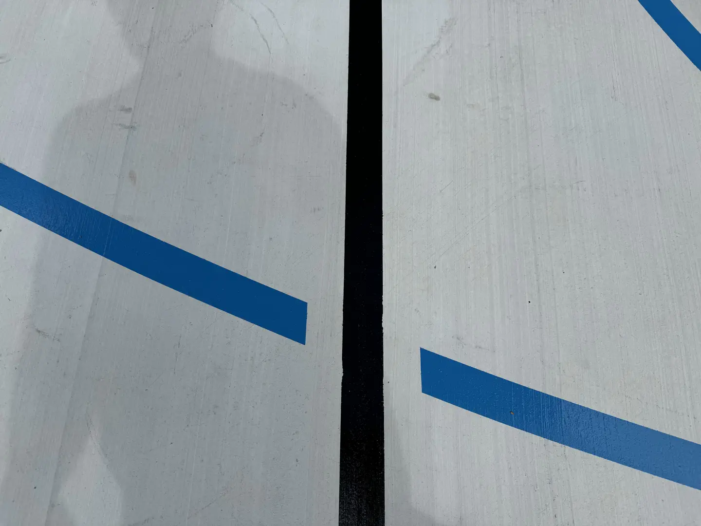 Blue and black lines on a white court surface