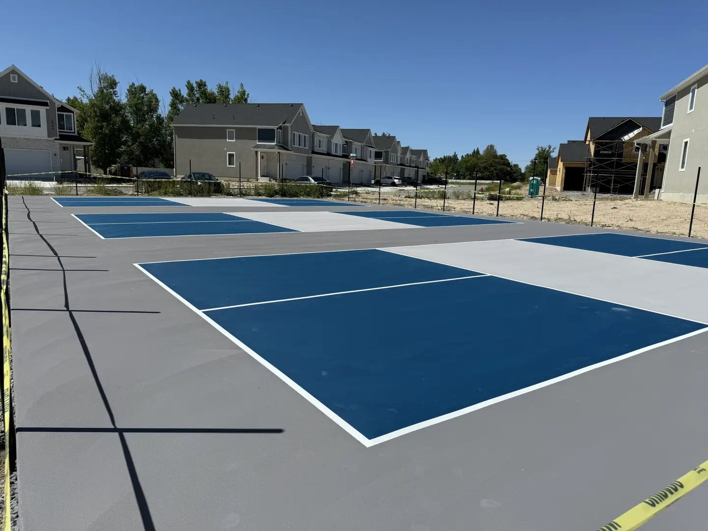 Newly painted pickleball courts with blue and gray surfaces.