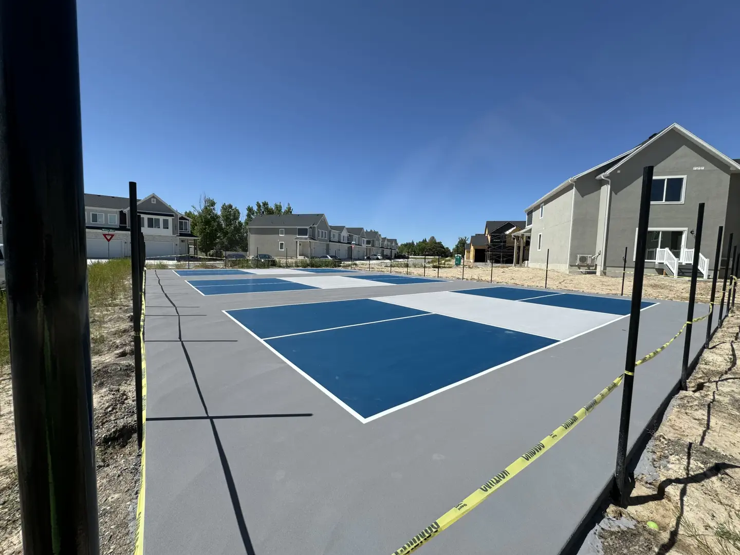 New pickleball courts under construction with blue and grey surfacing.